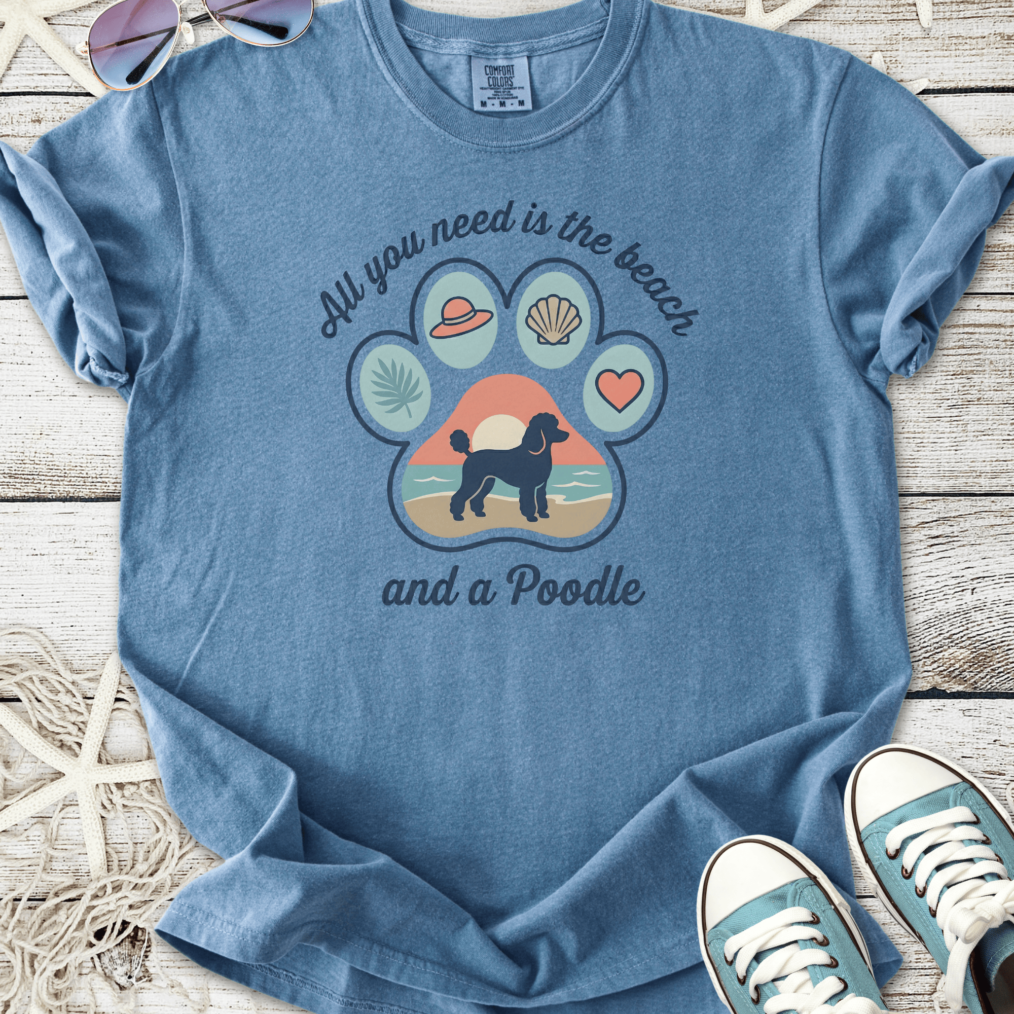 Blue graphic t-shirt with beach-themed design and poodle illustration, perfect for dog lovers.