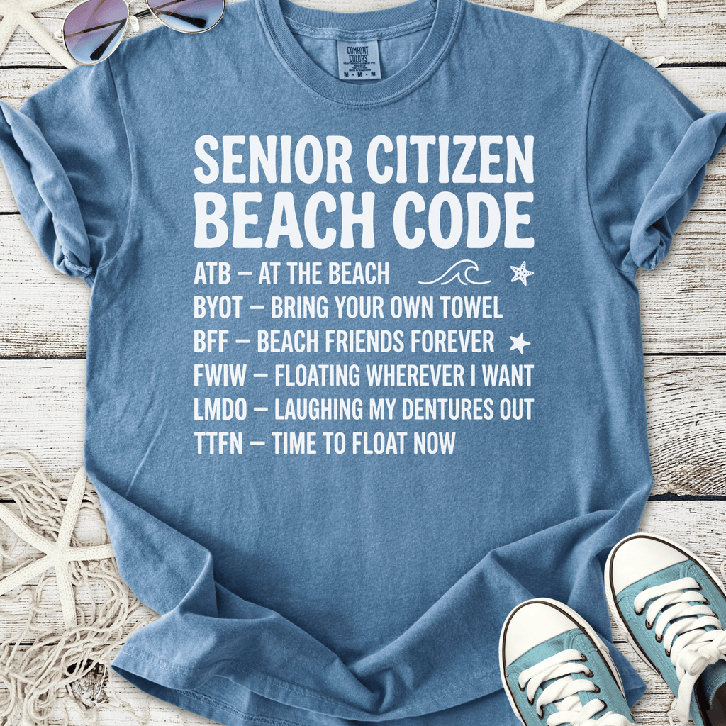 Light blue t-shirt with 'Senior Citizen Beach Code' graphic, featuring fun phrases, perfect for beach lovers.