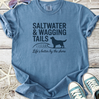 Blue graphic t-shirt featuring 'Saltwater & Wagging Tails' design, perfect for beach lovers and dog owners.