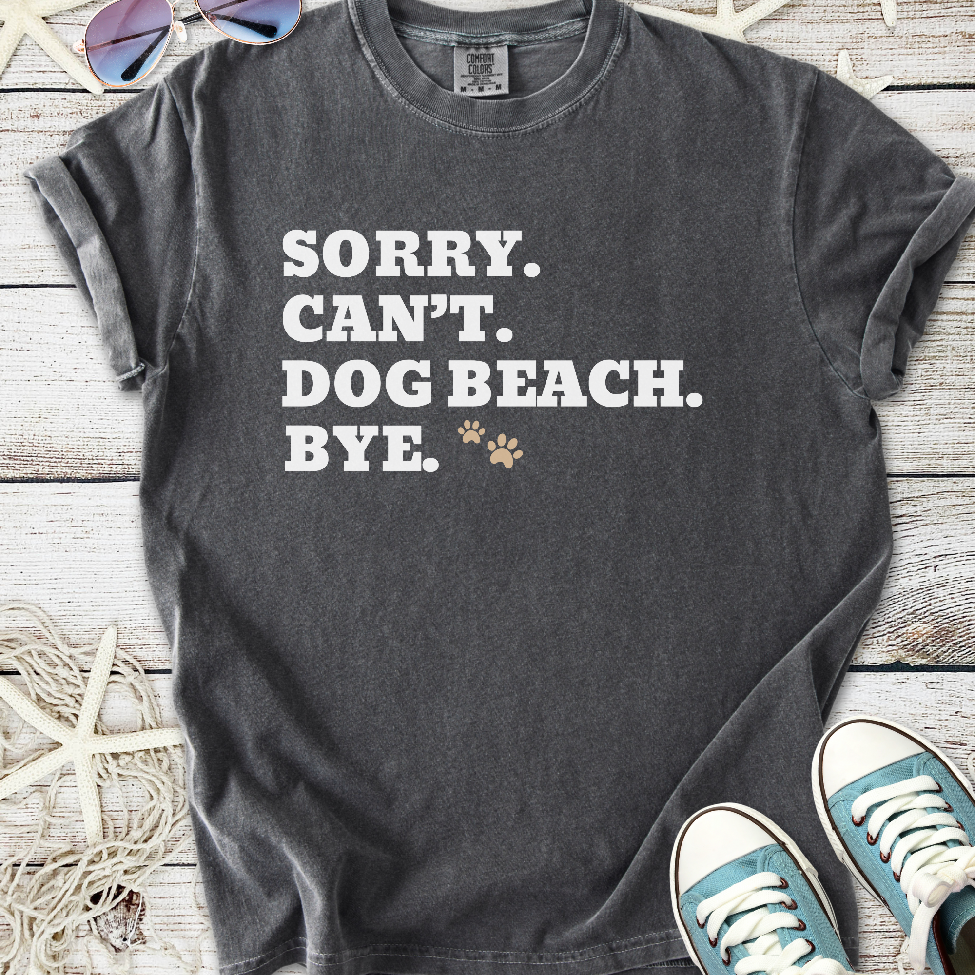 Gray graphic t-shirt with 'Sorry. Can't. Dog Beach. Bye.' text, perfect for dog lovers and beach outings.