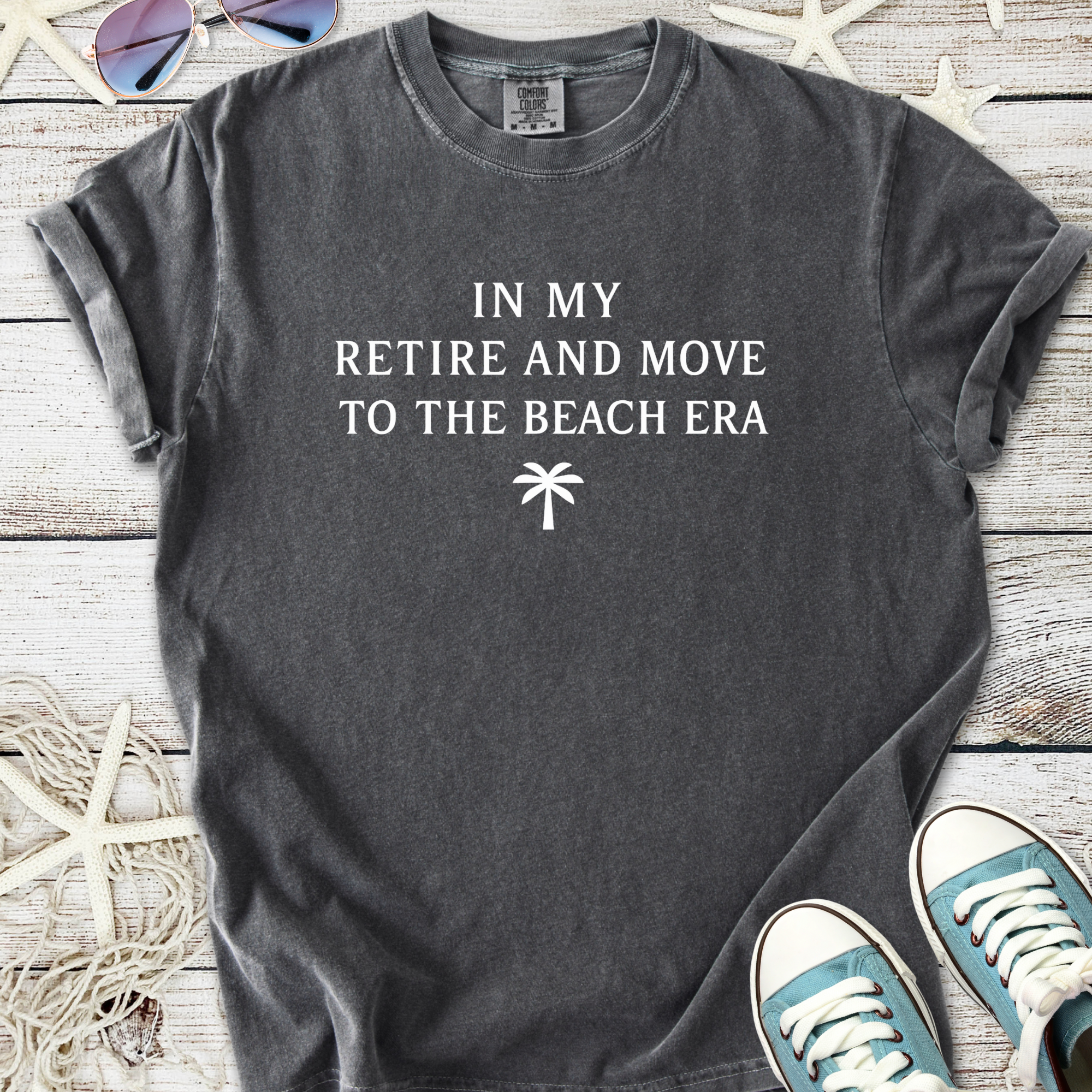 Gray graphic t-shirt with 'In My Retire and Move to the Beach Era' text, perfect for casual beachwear.
