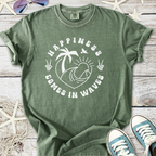 Green cotton tee with 'Happiness Comes in Waves' graphic, featuring palm trees and waves design.