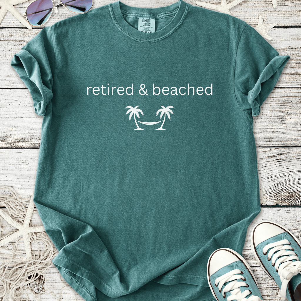 Teal cotton t-shirt featuring 'retired & beached' with palm tree graphic, perfect for beach lovers.