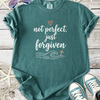 Teal graphic tee with 'not perfect, just forgiven' text, featuring waves and a cross design.