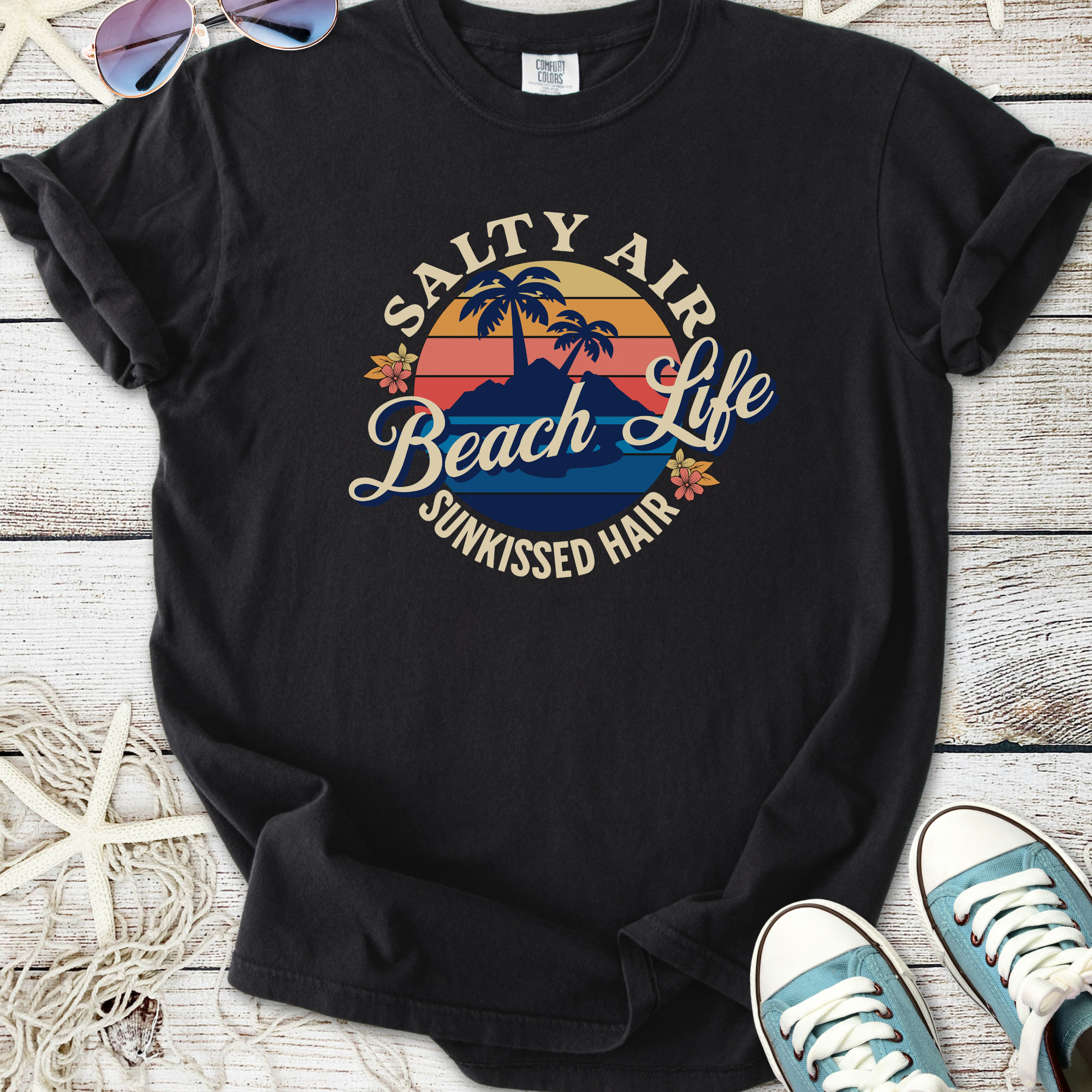 Black graphic t-shirt with 'Salty Air Beach Life Sunkissed Hair' design and palm tree motif.