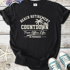 Black t-shirt featuring 'Beach Retirement Countdown' graphic, perfect for relaxed office escape.