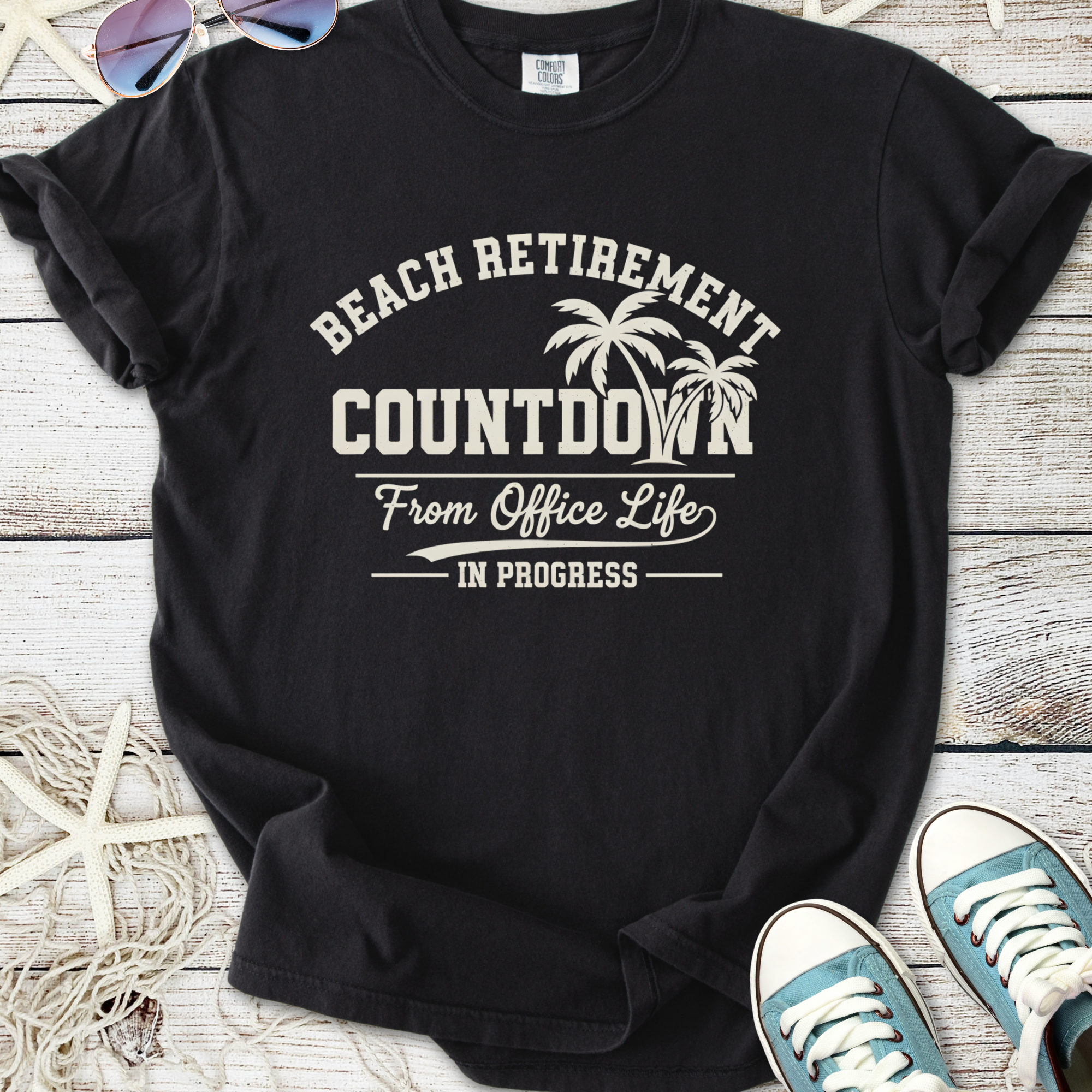 Black t-shirt featuring 'Beach Retirement Countdown' graphic, perfect for relaxed office escape.