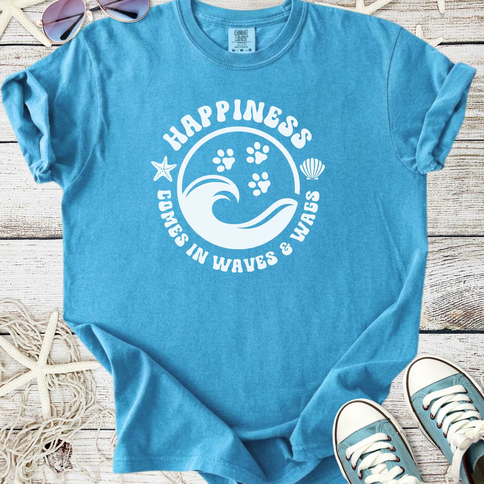 Light blue happiness t-shirt with wave and paw print graphic, perfect for beach lovers.