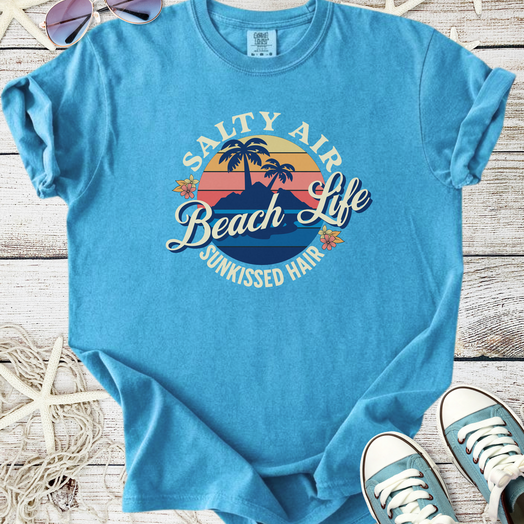 Light blue graphic t-shirt featuring "Salty Air Beach Life" design with palm trees and flowers.