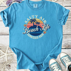 Light blue graphic t-shirt featuring "Salty Air Beach Life" design with palm trees and flowers.