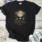 Black graphic t-shirt featuring 'Find me under the palms' with palm trees and sun design.