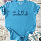 Light blue retirement crew t-shirt featuring turtle, pelican, crab, and bird graphics.