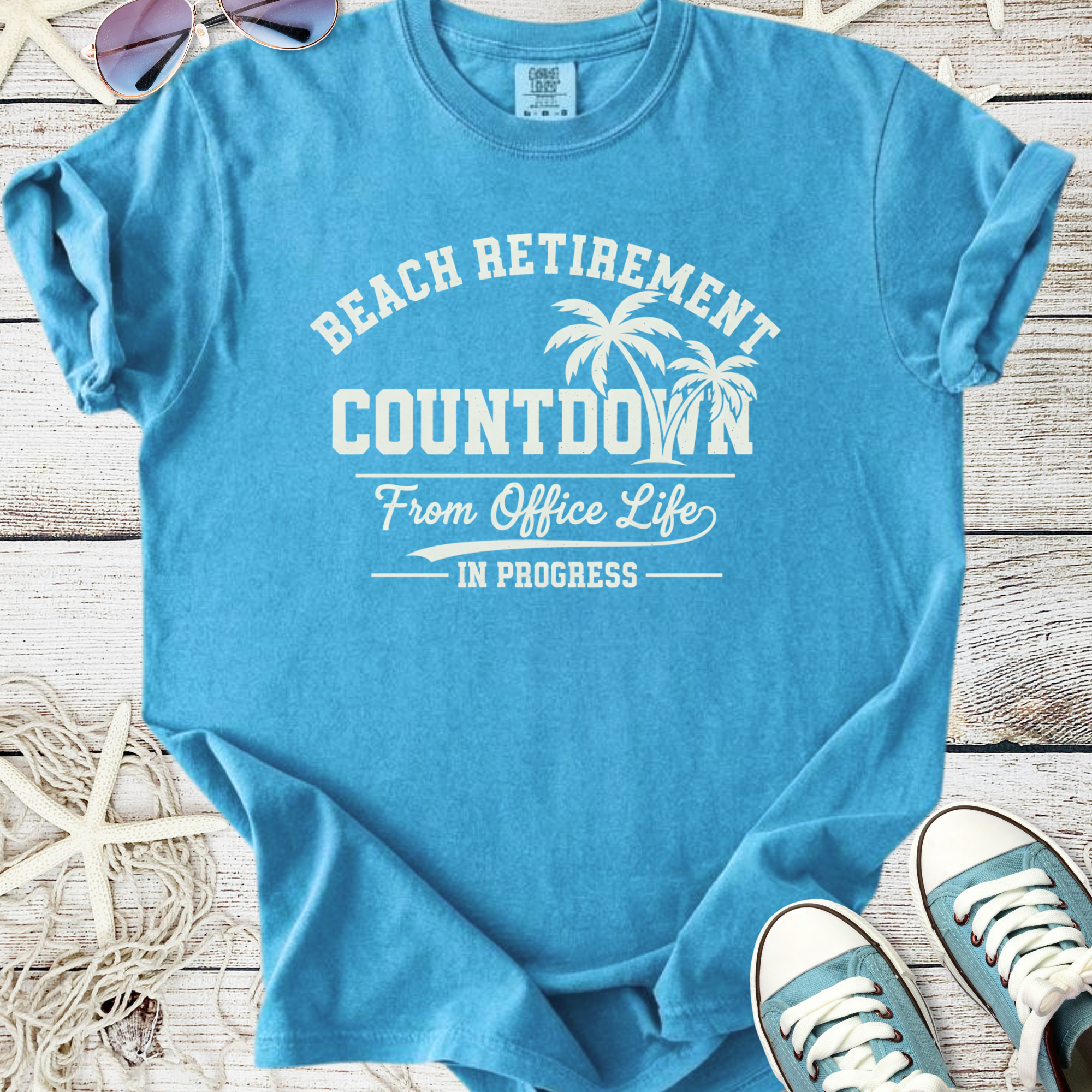 Blue cotton t-shirt with 'Beach Retirement Countdown' graphic, perfect for summer and beach lovers.