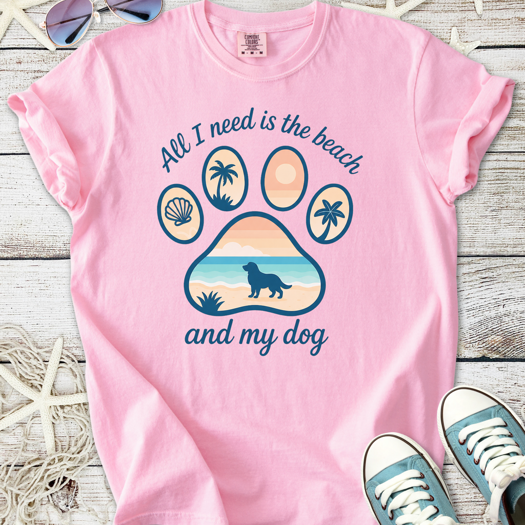 Pink cotton t-shirt with 'All I need is the beach and my dog' graphic, featuring a paw design and beach scene.