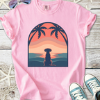 Pink women's t-shirt featuring a sunset design with a dog silhouette and palm trees, made from soft cotton.