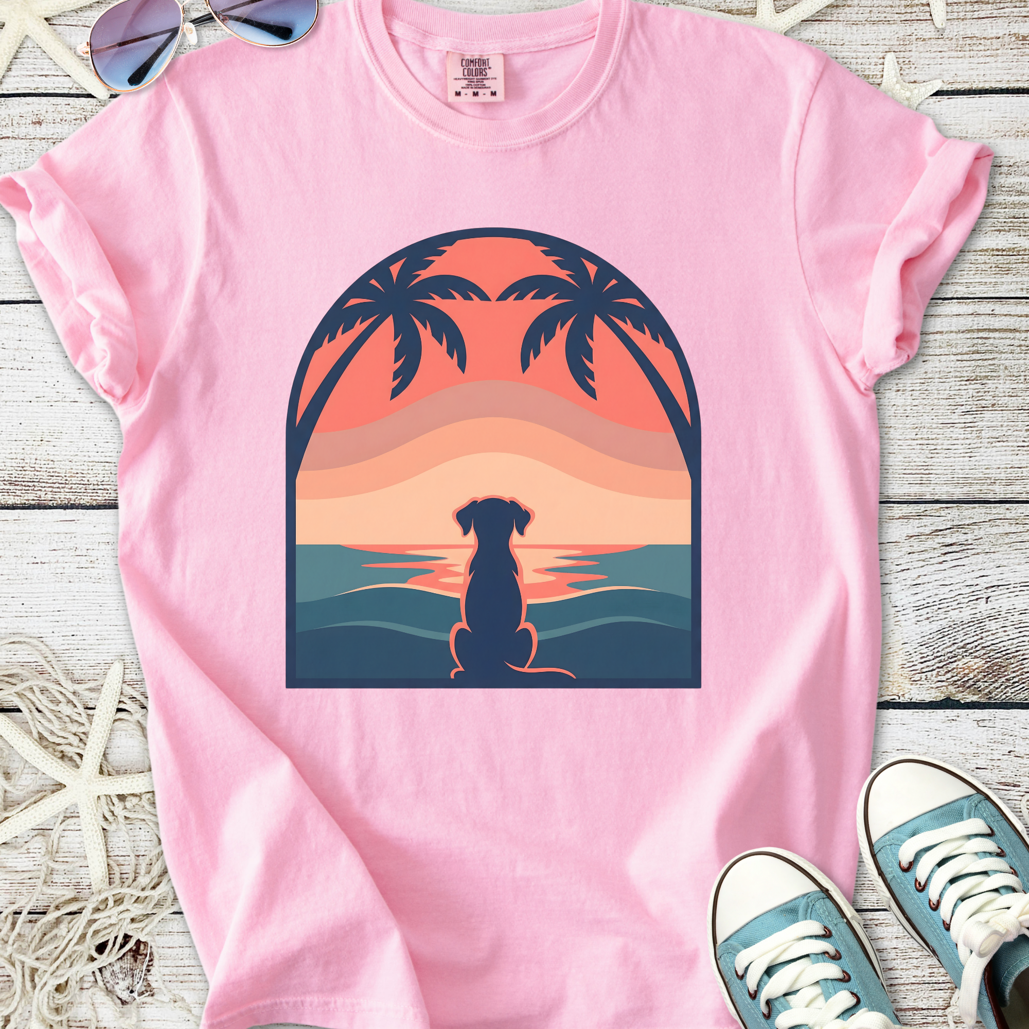 Pink women's t-shirt featuring a sunset design with a dog silhouette and palm trees, made from soft cotton.