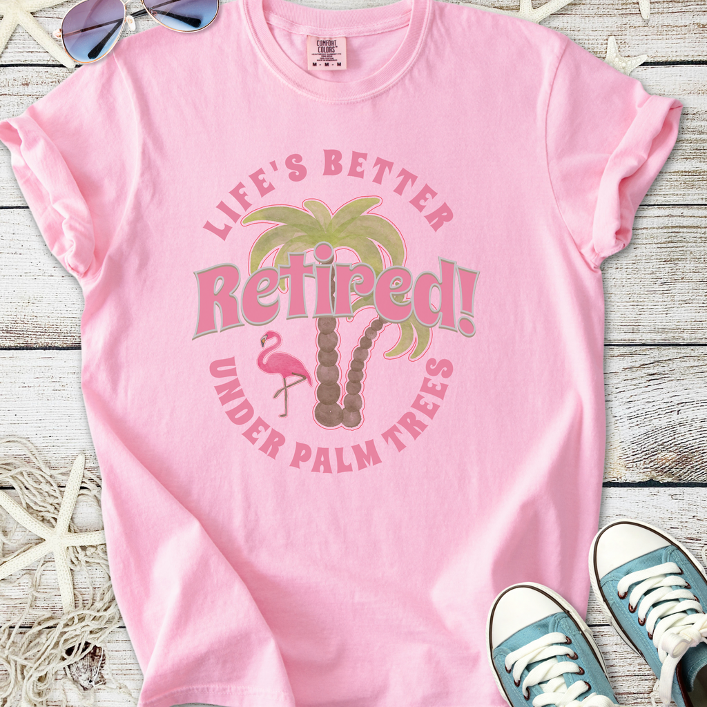 Light pink retired t-shirt featuring palm tree and flamingo graphic, perfect for relaxed summer vibes.