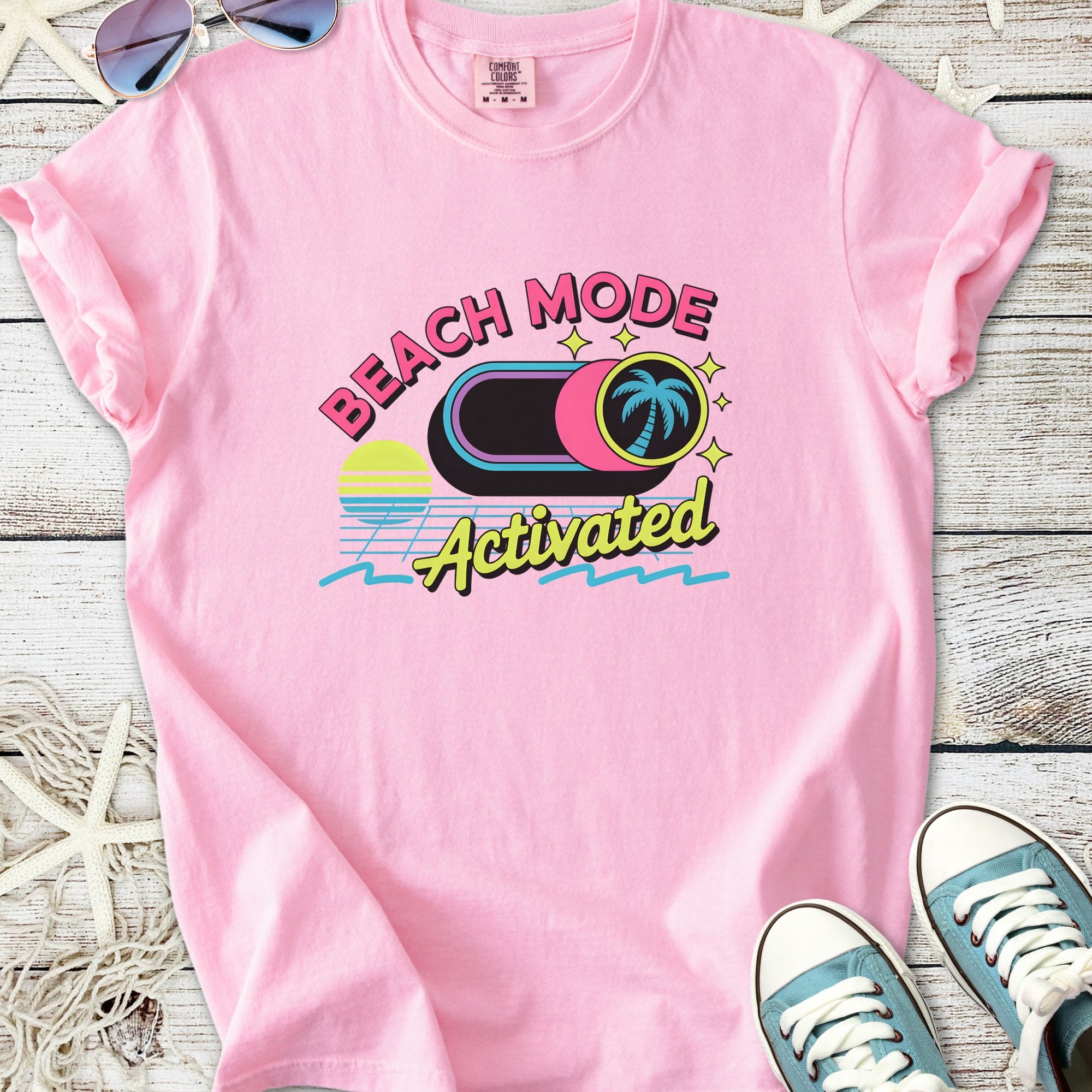 Pink cotton t-shirt featuring 'Beach Mode Activated' graphic with palm tree design.