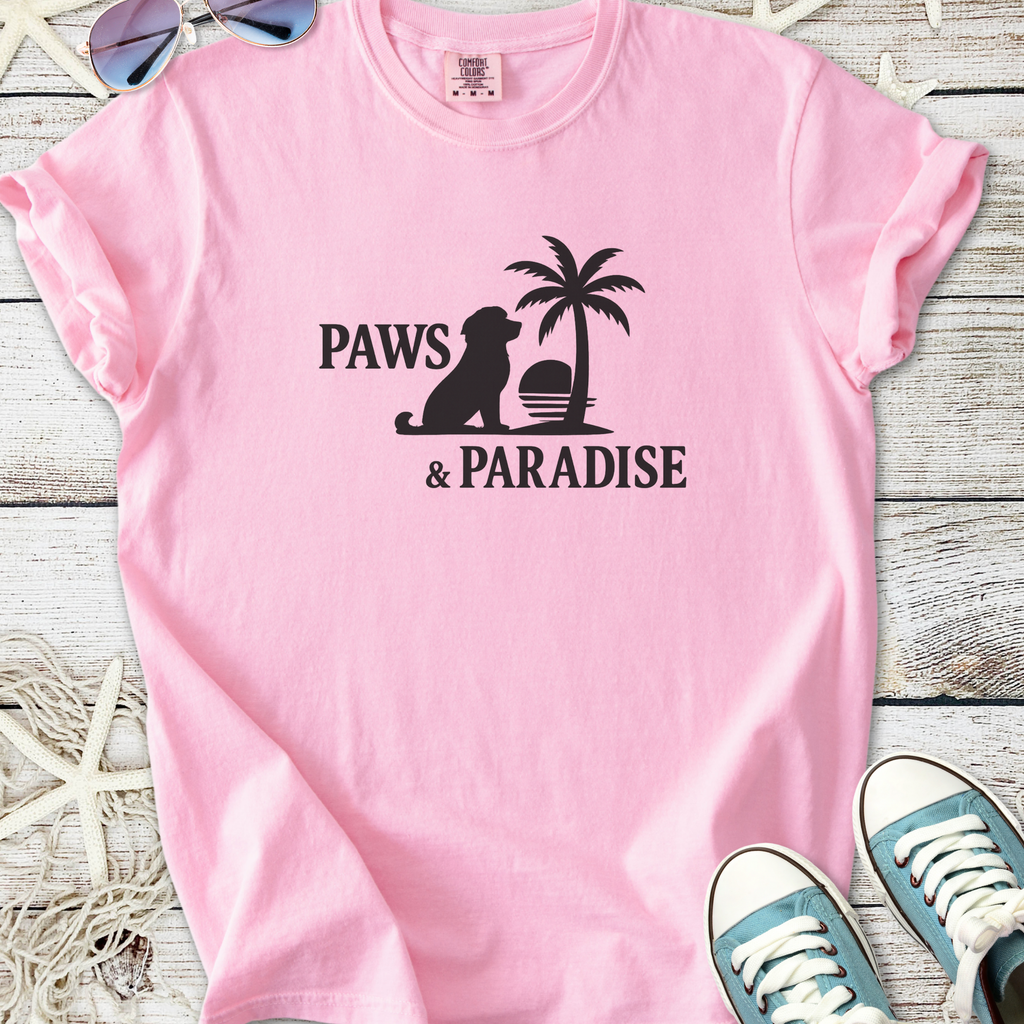 Light pink t-shirt featuring 'Paws & Paradise' graphic with a dog and palm tree design.