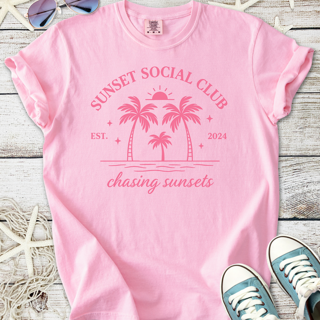 Pink cotton t-shirt with 'Sunset Social Club' graphic, featuring palm trees and beach motif, perfect for summer.