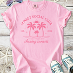 Pink cotton t-shirt with 'Sunset Social Club' graphic, featuring palm trees and beach motif, perfect for summer.