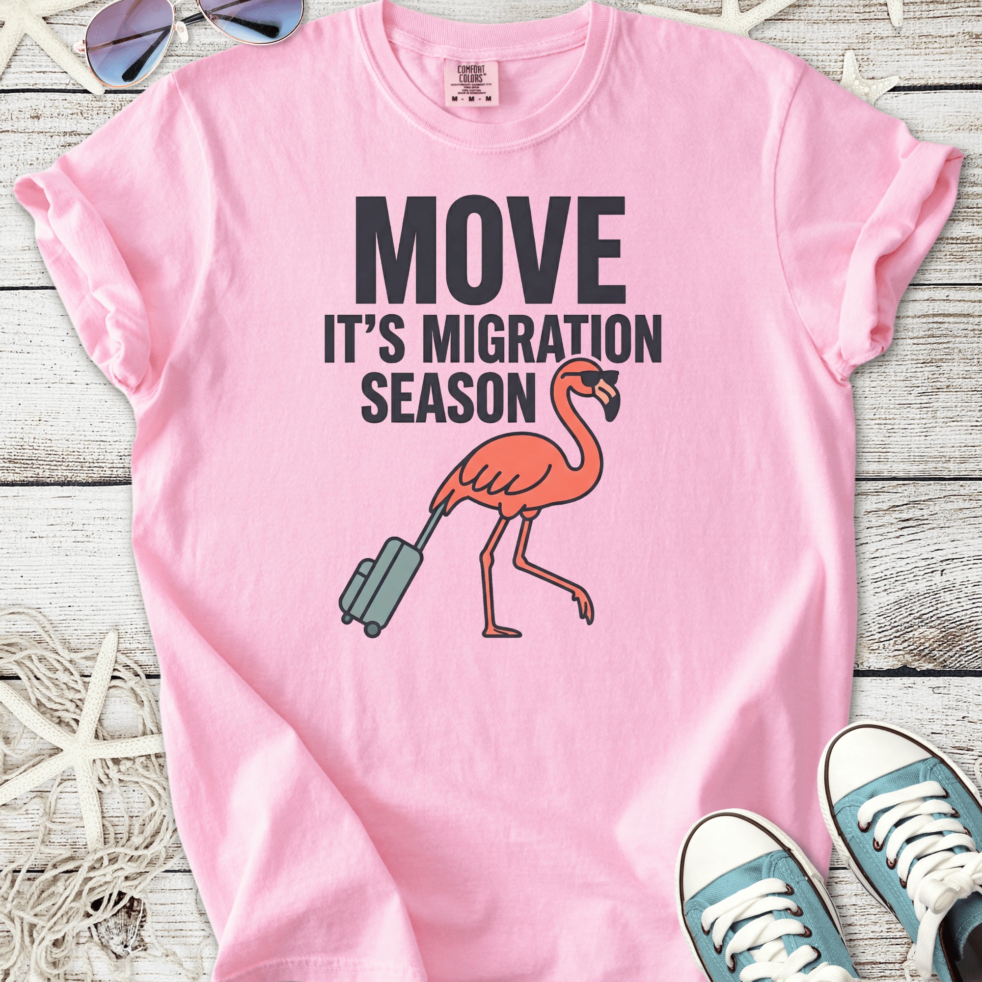 Pink cotton t-shirt featuring a flamingo and migration season graphic design.