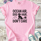 Pink graphic tee featuring 'Ocean Air, Dog Hair, Don't Care' design with a dog and starfish.