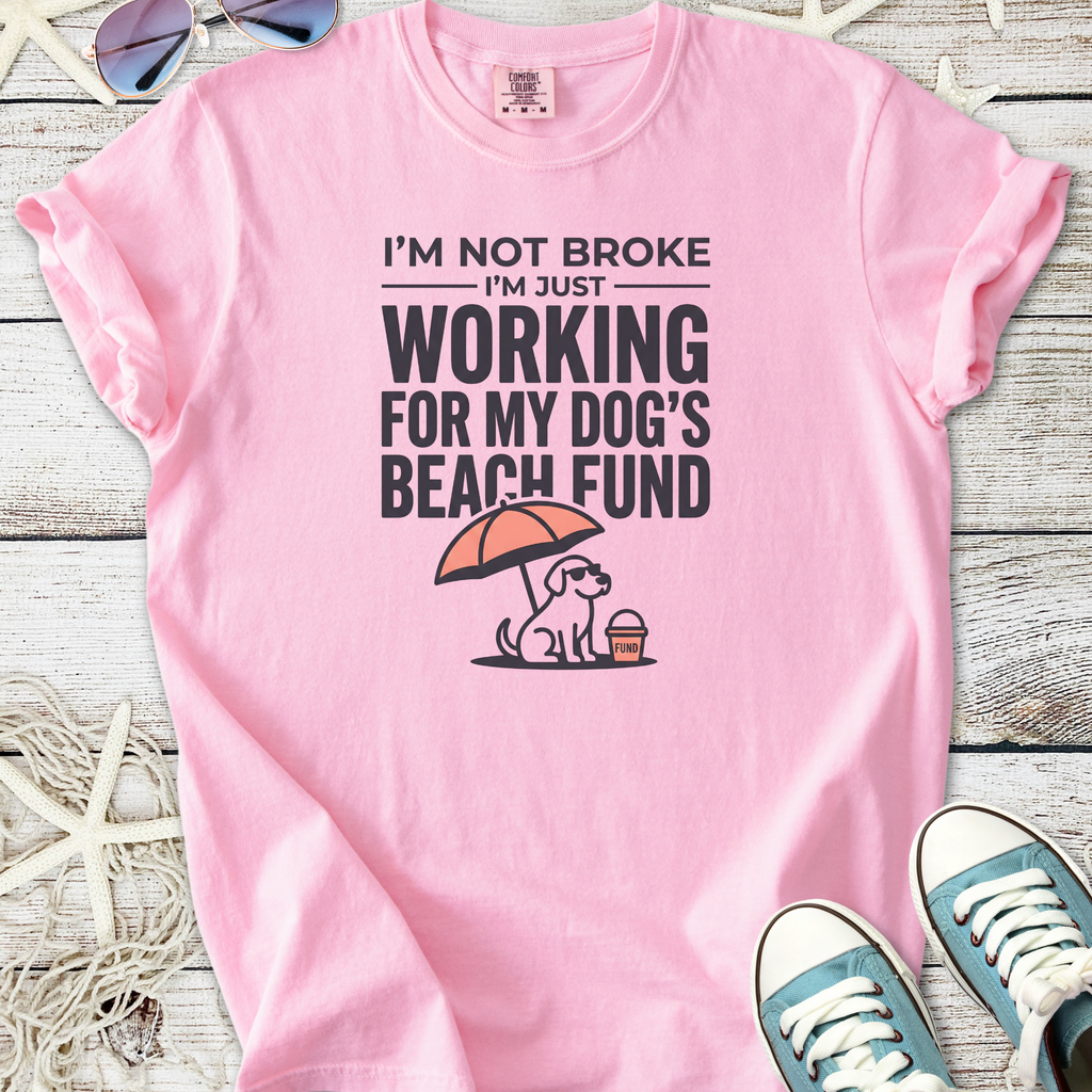 Pink graphic t-shirt with humorous text about working for dog's beach fund, casual style.