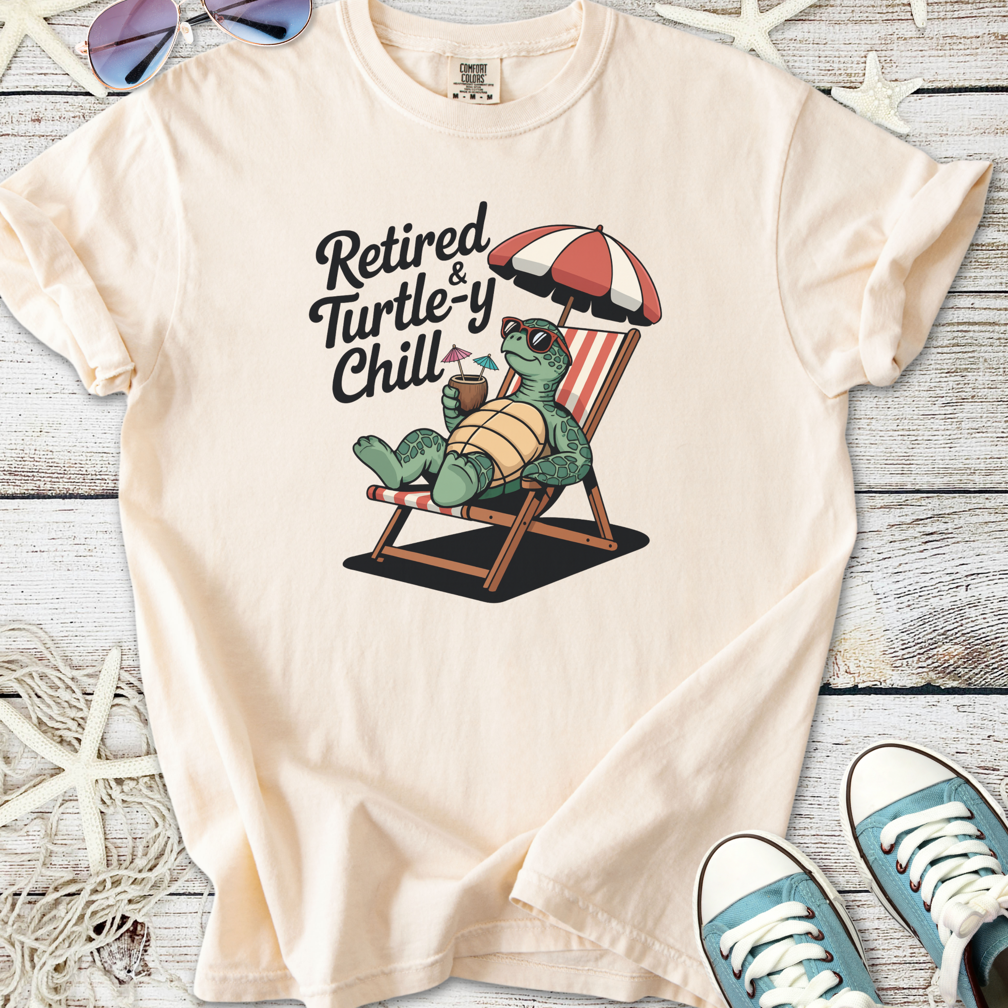 Light beige t-shirt featuring a relaxed turtle graphic with the text 'Retired & Turtle-y Chill'.