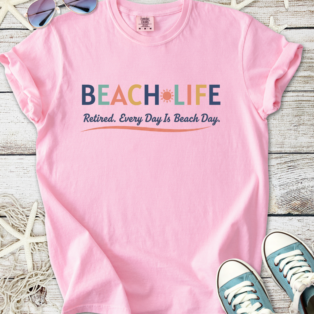Pink cotton t-shirt with 'BEACH LIFE' print, perfect for retirees, celebrating beach days.