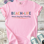 Pink cotton t-shirt with 'BEACH LIFE' print, perfect for retirees, celebrating beach days.