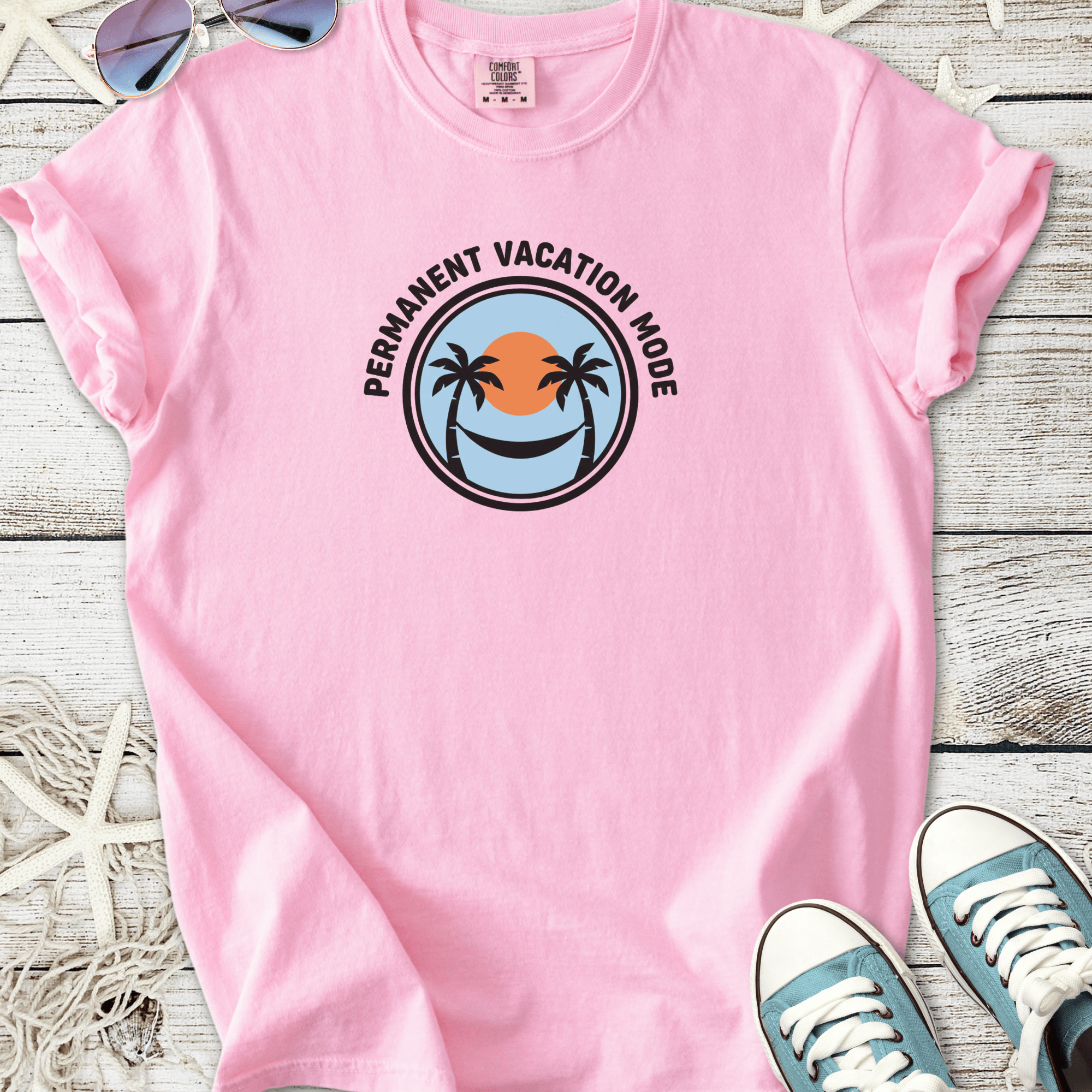 Pink cotton t-shirt with 'Permanent Vacation Mode' graphic featuring palm trees and sunset.