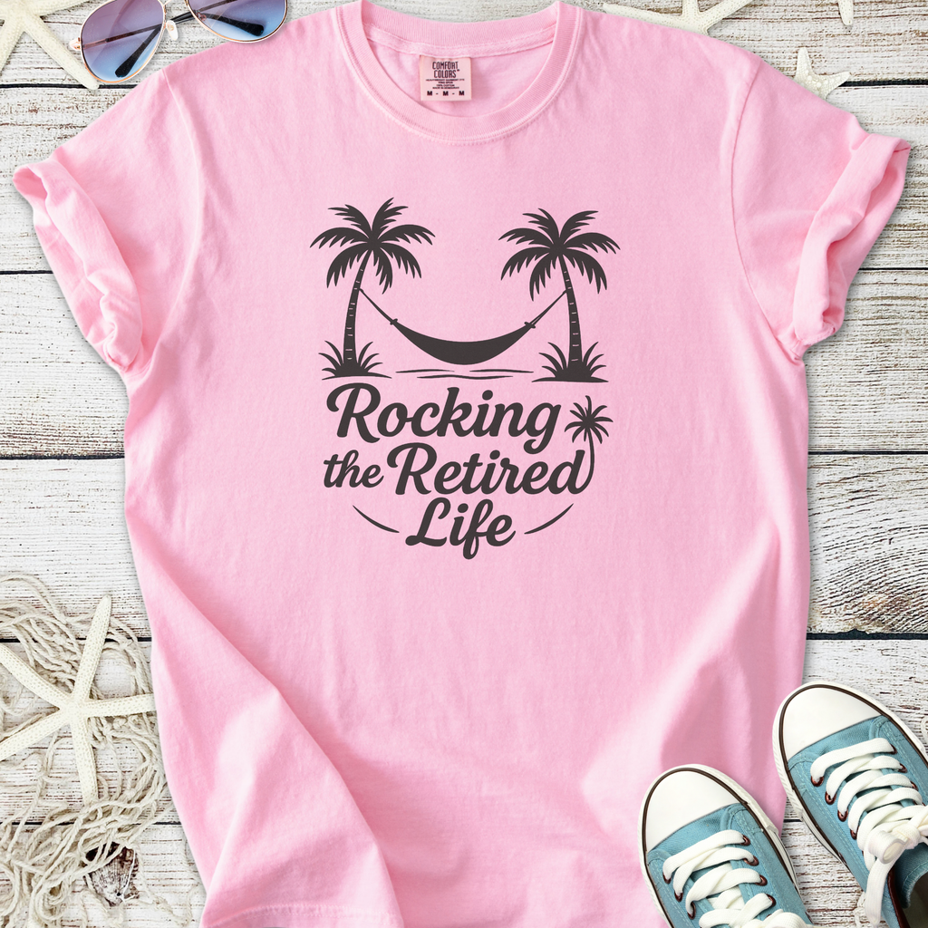 Pink cotton t-shirt with 'Rocking the Retired Life' print and palm trees, perfect for casual wear.