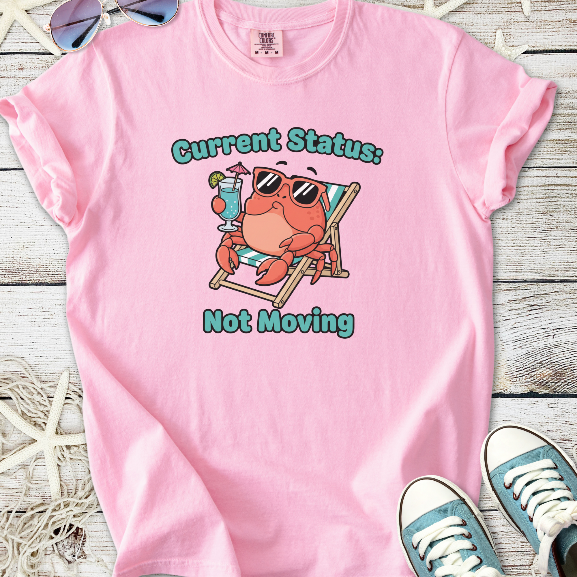 Funny pink t-shirt featuring a lounging crab with sunglasses, saying 'Current Status: Not Moving'.