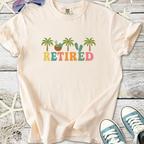 Light peach retired graphic t-shirt featuring palm trees and beach elements, perfect for summer outings.