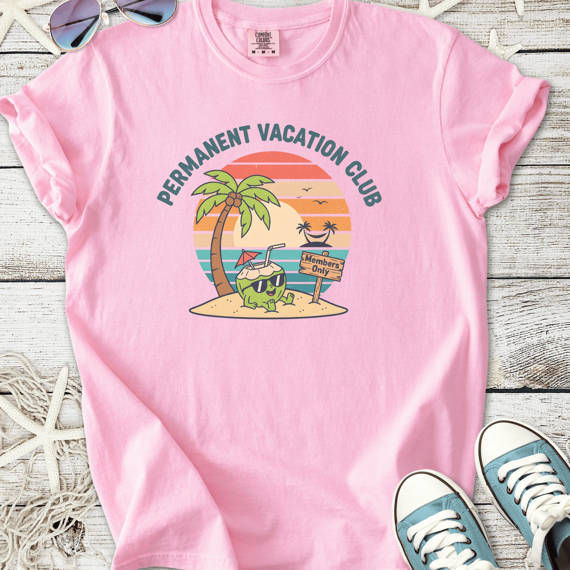 Pink t-shirt featuring 'Permanent Vacation Club' graphic with palm trees and beach theme.