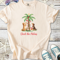 Light beige t-shirt with festive dog graphic and text 'Deck the Palms', cotton material, perfect for holiday wear.