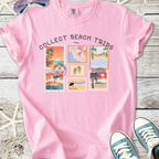 Pink graphic t-shirt featuring 'Collect Beach Trips' design with vibrant stamp illustrations.