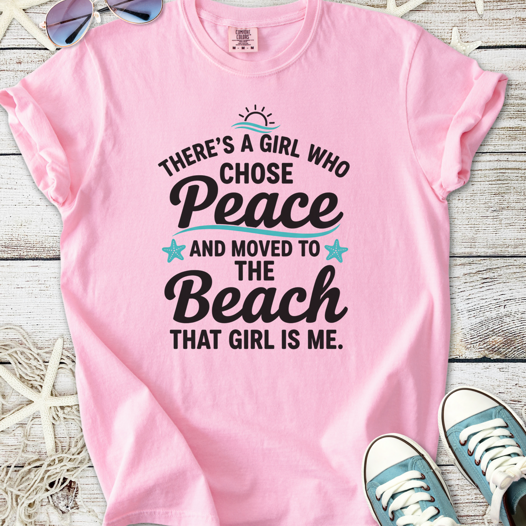 Pink graphic tee with beach-themed quote, perfect for casual summer style.