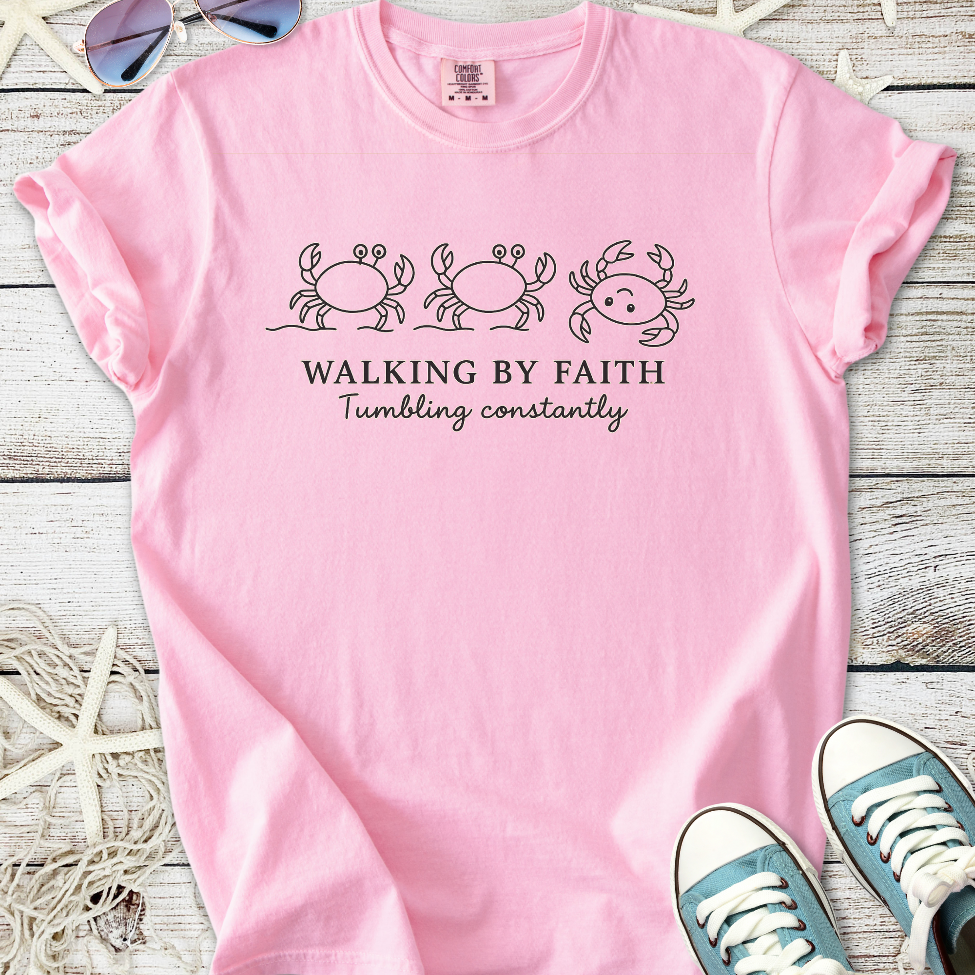 Pink graphic t-shirt featuring crabs and the phrase 'Walking by Faith' for a fun, casual style.