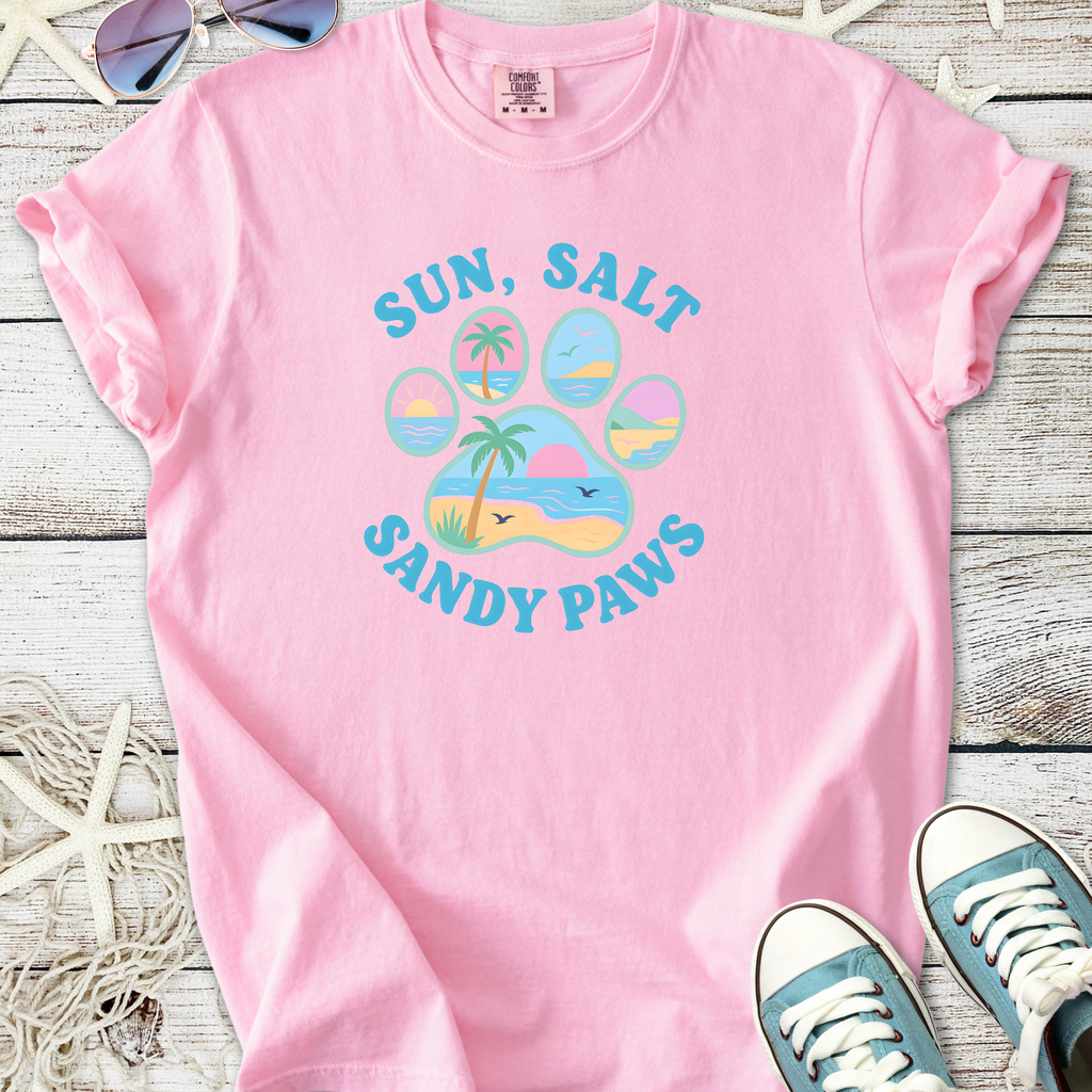 Light pink t-shirt featuring 'Sun, Salt, Sandy Paws' graphic with beach theme, made from soft cotton.