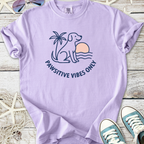 Light purple t-shirt featuring a dog silhouette, palm tree, and 'Pawsitive Vibes Only' design.