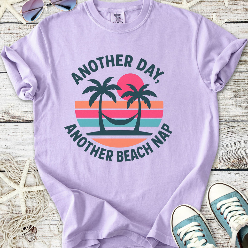 Light purple graphic t-shirt with 'Another Day, Another Beach Nap' text and palm tree design.