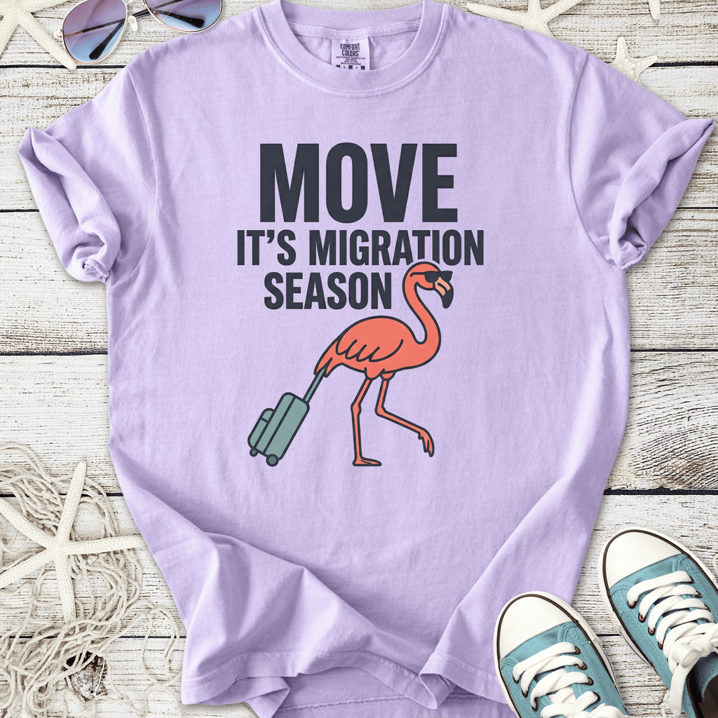 Lilac t-shirt with 'MOVE IT'S MIGRATION SEASON' and a flamingo graphic, perfect for casual wear.
