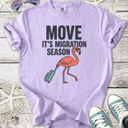 Lilac t-shirt with 'MOVE IT'S MIGRATION SEASON' and a flamingo graphic, perfect for casual wear.