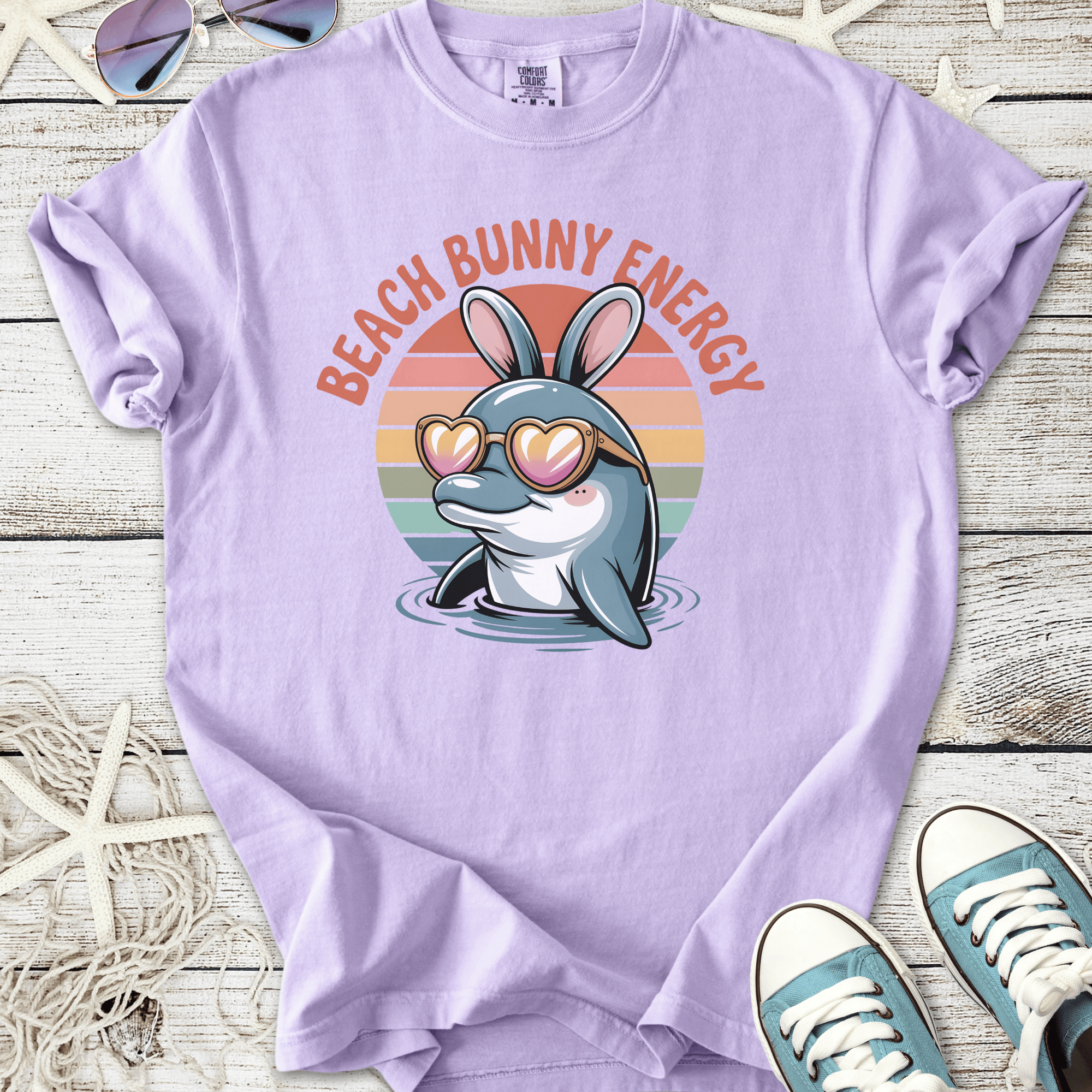 Lilac unisex t-shirt featuring a dolphin in sunglasses with 'Beach Bunny Energy' graphic.