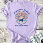 Purple t-shirt featuring Labrador design with beach theme, perfect for dog lovers.