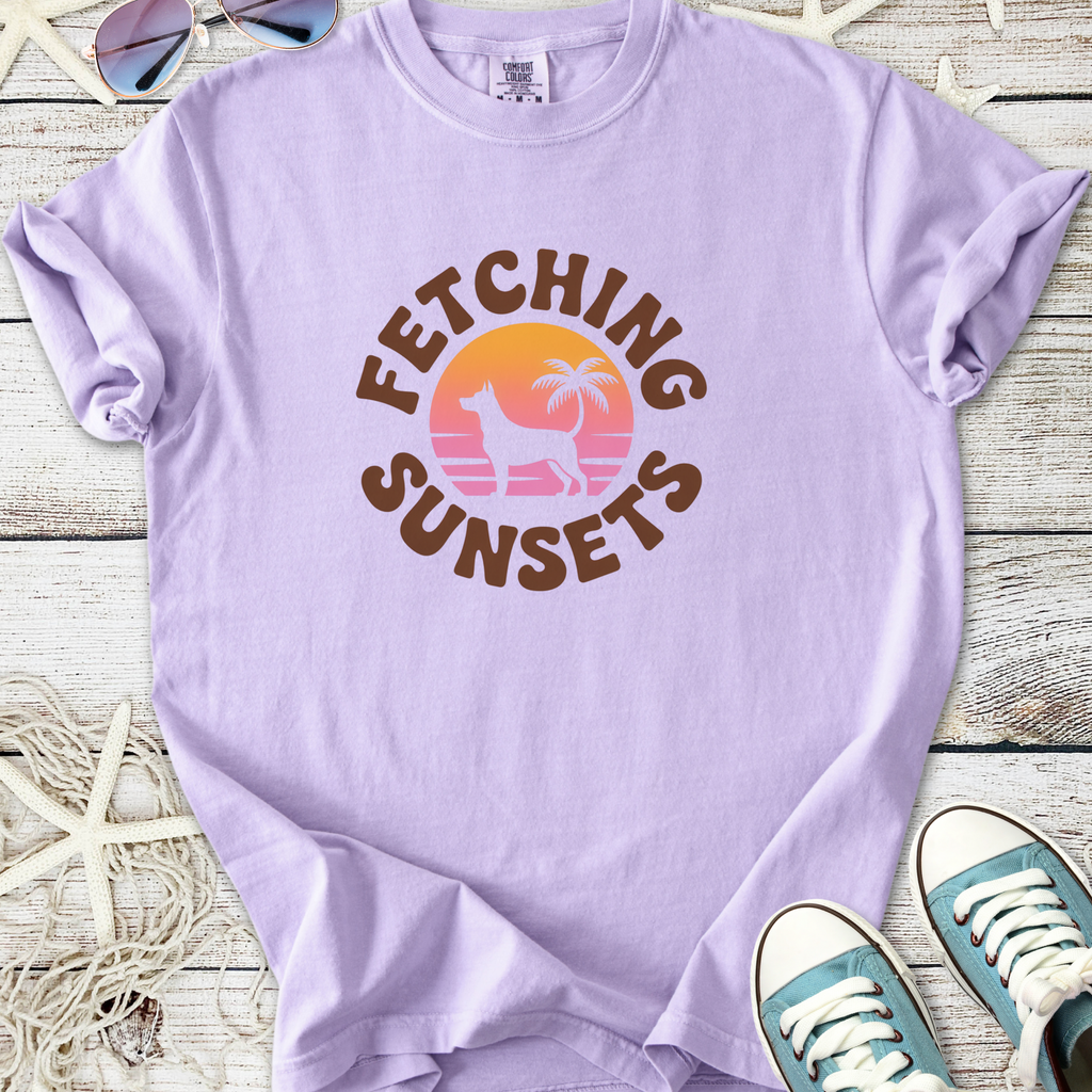 Light purple t-shirt with 'Fetching Sunsets' graphic, featuring a palm tree and sunset design.