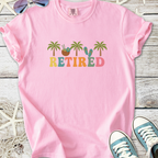 Light pink t-shirt with 'RETired' graphic, featuring palm trees and flip flops, perfect for casual wear.