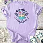 Lilac retired graphic tee with tropical drink design, perfect for casual summer wear.